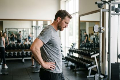 Homme musclé en train de s'étirer dans une salle de sport