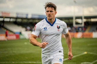 Joueur de rugby de l'équipe de France en maillot blanc lors d'un entraînement sur terrain en herbe, illustrant la performance sportive en Bleu