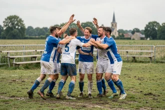 Joueurs de football amateur du district de l'Aisne célébrant un but sur un terrain de village