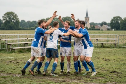 Joueurs de football amateur du district de l'Aisne célébrant un but sur un terrain de village