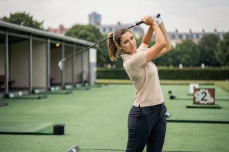 Femme pratiquant le golf sur un practice accessible en transports en commun près de Paris
